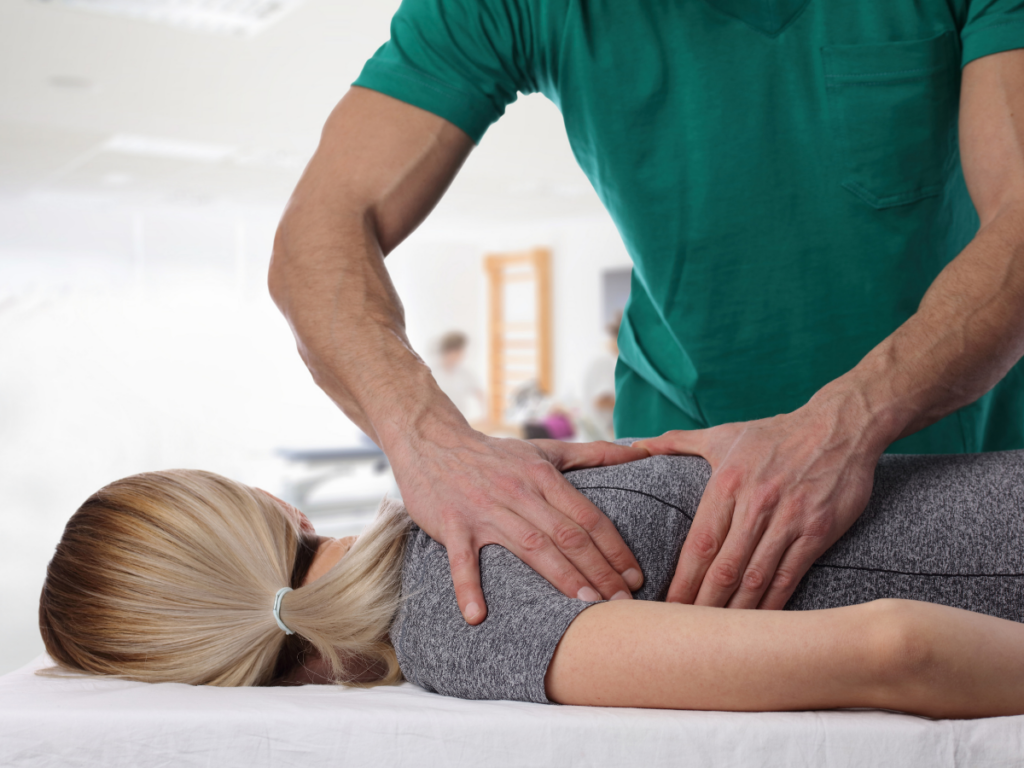 twwo hands placed on the upper back of a blonde female, like a massage